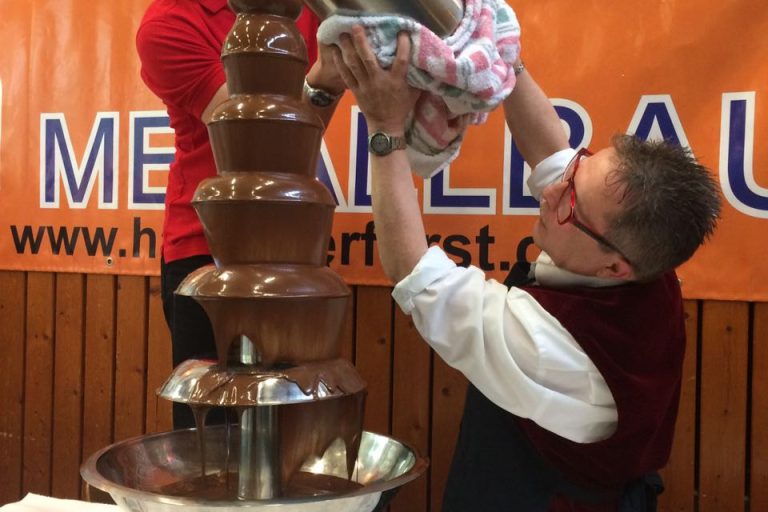 Clemens Backs mit Kollegen befüllen den Schokobrunnen